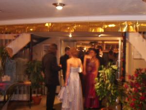 Groep feestelijk geklede mensen in een chique warm verlichte binnenruimte mogelijk tijdens een gala of evenement op een partyschip