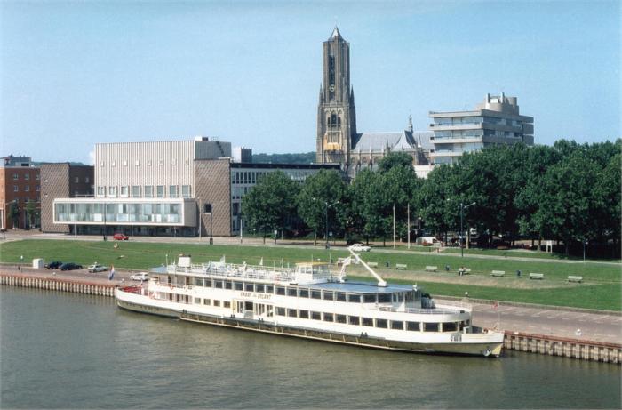 Partyschip Graaf van Bylant aangemeerd aan de kade in Arnhem met de Eusebiuskerk en moderne gebouwen op de achtergrond